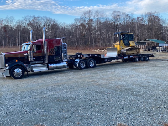 Kenworth lowboy hauling a Komatsu dozer to an HGS Contracting job site