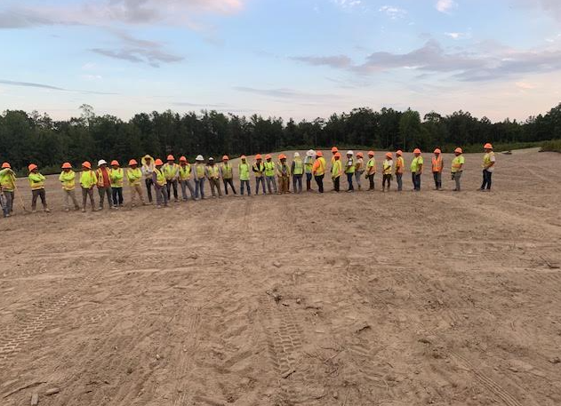 HGS Contracting crew lined up at dusk on a cleared job site