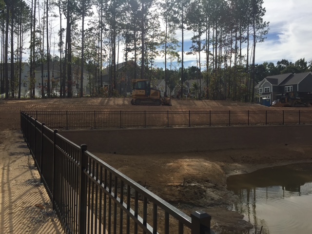 Dozer finishing slopes around a residential stormwater pond