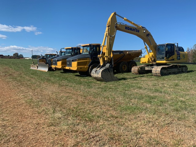 Komatsu excavator, articulated haul truck, and dozer staged on a job site