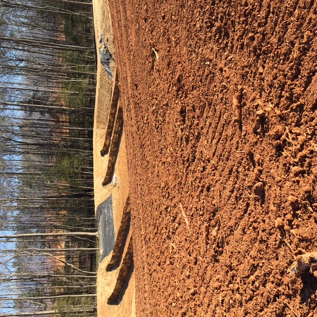 Graded pad with erosion control berms and slope protection installed